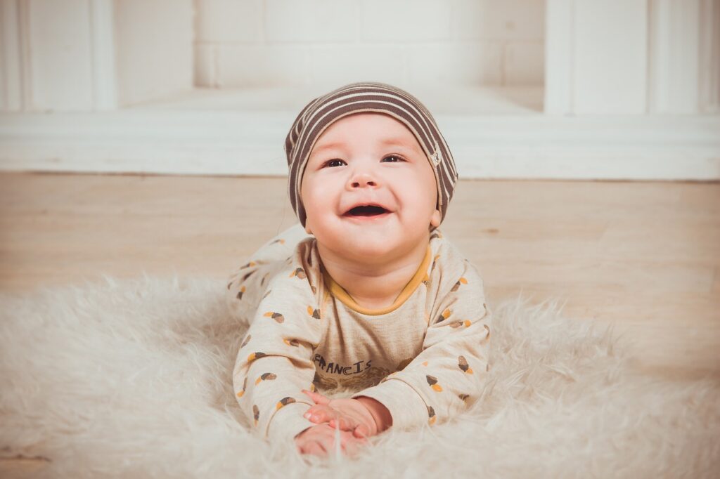 a baby smiling with wearing a cap.